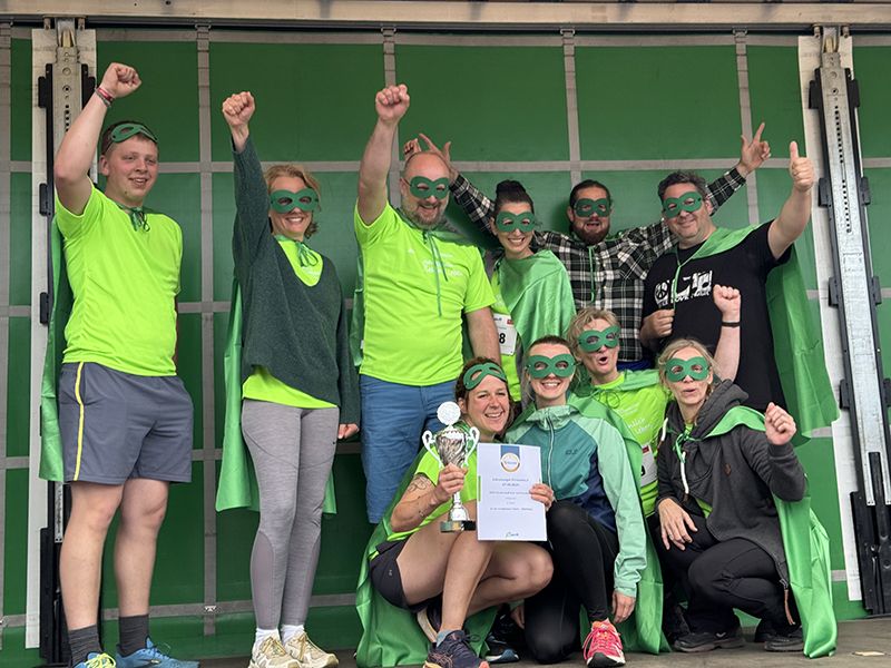 Superheld*innen bei der Überreichung des Pokals für den 2. Platz